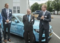 Men in suits in front of blue car