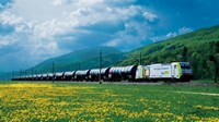 Train travelling through mountains and fields