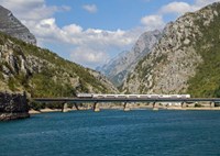 Train going through mountains and river valley