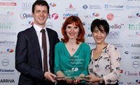 People posing for photo with award