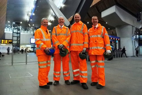 Four men in orange safety suits