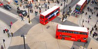 Red buses moving through bus intersection