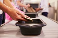 People putting phone into security check bucket