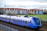 Blue train driving past Swedish town