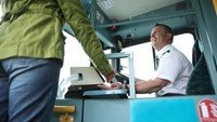 Passenger boarding bus and talking to bus driver