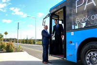Two men standing in doorway of blue bus