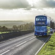 Blue double decker bus on the road