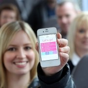 Woman holding First Bus app on phone