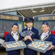 Flight attendants standing in front of two buses