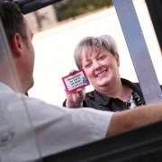 Older woman holding journey card to bus driver