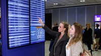 Women looking up at airport information board