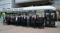 People in suits standing in front of bus