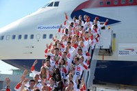 People standing on stairway next to plane