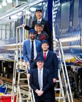 People standing on stairs next to new train