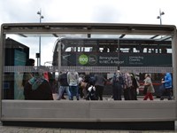 People waiting at glass bus stop