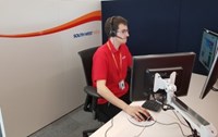 Man in red shirt and headset sitting at computer