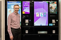 Man posing next to ticket machine