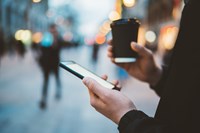 Woman holding phone and coffee