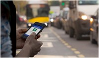 Person holding phone in front of traffic