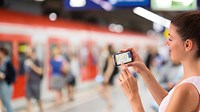 Woman with smartphone on trainplatform