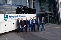 6 men standing next to bus