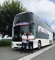Two men in front of a double decker bus