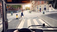 View of person walking across zebra-crossing from inside a bus