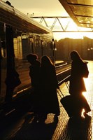 Silhouetted women boarding a train 