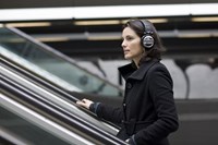 Woman with headphones on escalator 