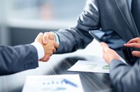 Two people in suits shaking hands